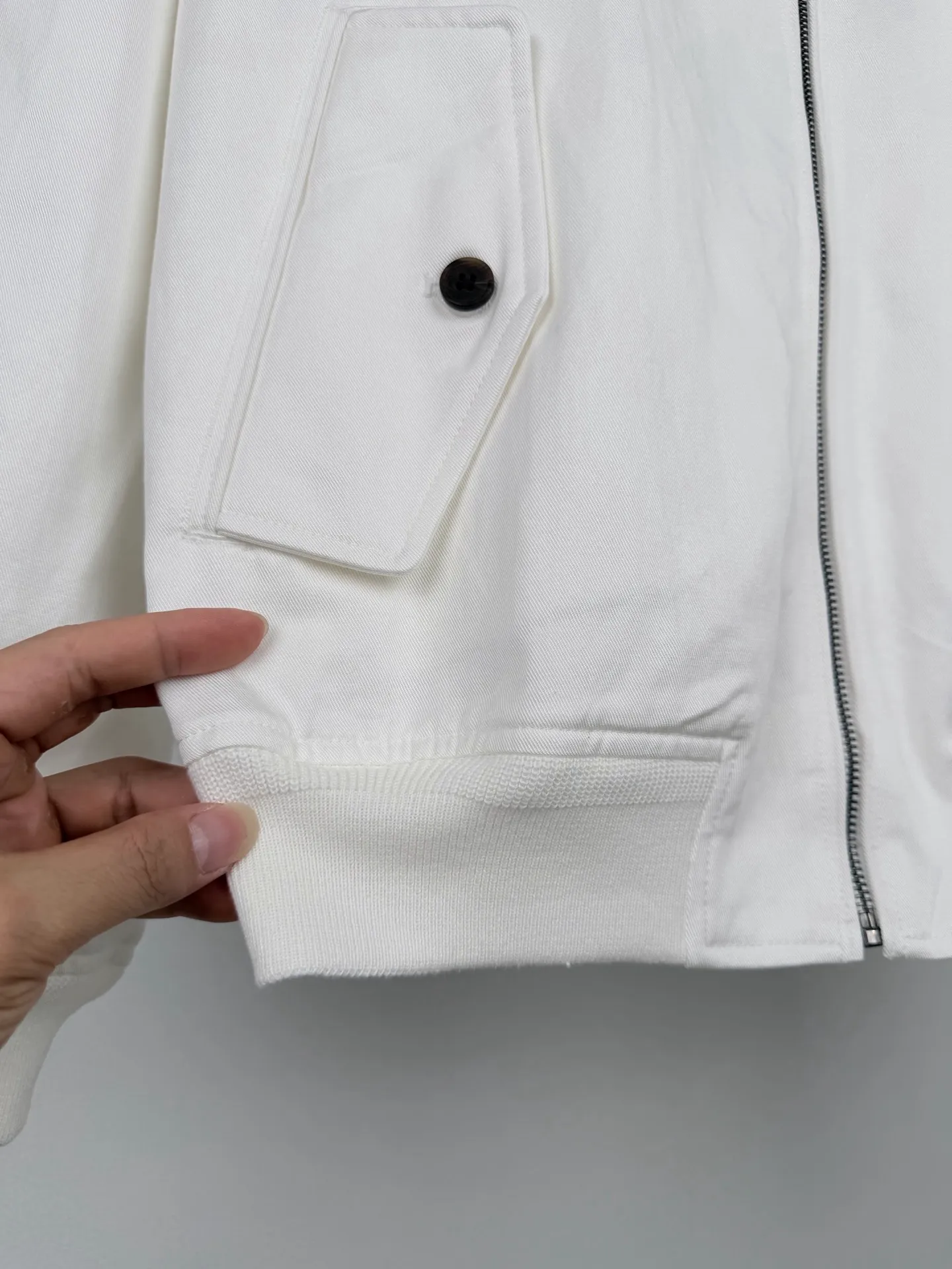 Ralph Lauren embroidered zipper jacket, custom obsidian bamboo honking oblique brocade, crisp and stylish, warm and skin-friendly, radiant milky white spreads over the body, the texture slowly unfolds with the light and shadow, showing unobtrusive classic elegance, exquisite pony embroidery on the left chest, dense and regular stitching, engraved with the brand's handed down totem, concealing the edge, and bringing with it timeless recognition. The neat stand-up collar is embellished with Retro brown buttons. The diagonal pockets are matched with ribs to create a short and relaxed silhouette. Between the plain white body, it embodies the restrained and elegant style of American old money. Process 1: Using imported machine embroidery technology. Using advanced computer control systems and precision mechanical components to achieve the iconic pony embroidery operation. High precision. The lines are smooth and delicate. Process 2: Template machine bag opening. Preset templates guide the position of opening the bag. The accuracy of the shape and size ensures the quality of the bag opening effect. Process 3: The fabrics have been fermented and washed. The hand feel and texture are better. Not easy to deform. Not easy to shrink. Not easy to fade. Maintain long-term beauty. Accessories: Customized 1:1 Ralph Lauren resin buckle. Customized 1:1 Ralph Lauren zipper. Customized 1:1 Genuine Leather lanyard. Customized 1:1 Ralph Lauren trademark. Version: Loose version Size: S M L XL